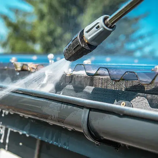 Mr. Softwash technician cleaning residential gutters